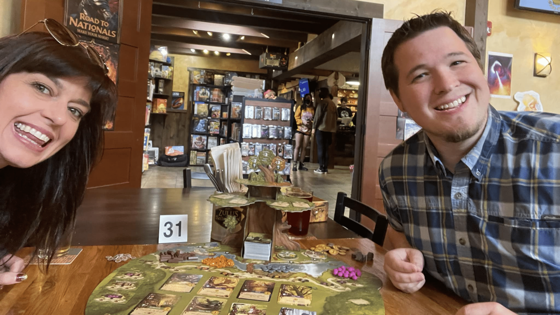Two people sitting at a table with a board game at Zulu's in Bothell